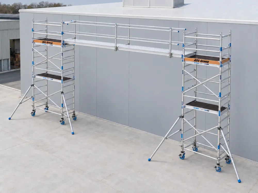Pasarela de aluminio ASC con dos barandillas montada entre dos torres móviles delante de una fachada